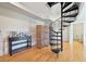 Basement featuring a spiral staircase, storage units, and wood flooring at 5677 S Park Pl # 311A, Greenwood Village, CO 80111