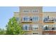 Exterior shot of an apartment building with beige siding and multiple balconies at 5677 S Park Pl # 311A, Greenwood Village, CO 80111