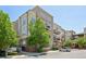 Exterior shot of an apartment building with beige siding and multiple balconies and street parking at 5677 S Park Pl # 311A, Greenwood Village, CO 80111