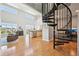 Open-concept living space with high ceilings, hardwood floors, and a modern spiral staircase at 5677 S Park Pl # 311A, Greenwood Village, CO 80111