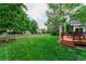 Lush green backyard with a wooden deck, mature trees, and a charming wooden fence at 2204 Lasalle St, Superior, CO 80027