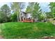 Expansive backyard with lush green grass, a wooden deck, and mature trees at 2204 Lasalle St, Superior, CO 80027