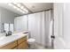 Bathroom with a wood-finish vanity, white shower curtain, and modern fixtures at 2204 Lasalle St, Superior, CO 80027