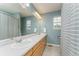 Bright bathroom featuring a long vanity with double sinks, framed mirror, and shower-tub combination at 2204 Lasalle St, Superior, CO 80027