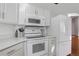 Bright kitchen features white cabinets, modern appliances and solid surface counters at 7040 Routt St, Arvada, CO 80004