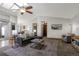 Open-concept living room with neutral tones, ceiling fan, and views of the dining area at 7040 Routt St, Arvada, CO 80004