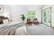 Sunlit bedroom showcasing a comfortable bed and a cozy sitting area with a view of the outdoors at 7548 S Crocker Ct, Littleton, CO 80120