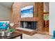 Detailed view of the brick fireplace, with a rustic design and adjacent living area, creating a cozy ambiance at 7548 S Crocker Ct, Littleton, CO 80120