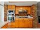 A close up of stainless steel appliances and wood cabinets set against a brick wall in the kitchen at 7548 S Crocker Ct, Littleton, CO 80120