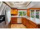 This kitchen has stainless steel appliances, orange walls, wood cabinets, and tile countertops at 7548 S Crocker Ct, Littleton, CO 80120