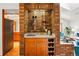 A wet bar with brick accent wall, wine storage, sink, and glass shelving at 7548 S Crocker Ct, Littleton, CO 80120