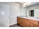 Bathroom featuring wooden cabinets, granite countertops, a large mirror, and dark flooring offering a modern aesthetic at 365 Casalon Pl, Superior, CO 80027