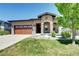 Inviting single-story home with a brick garage door, stone pillars, and verdant landscaping at 365 Casalon Pl, Superior, CO 80027