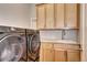 Laundry room with modern washer and dryer, sink, and wood cabinets for ample storage space at 365 Casalon Pl, Superior, CO 80027