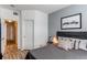 Cozy bedroom with adjoining bathroom entry featuring gray accent wall and artwork at 8500 E Jefferson Ave # 7B, Denver, CO 80237