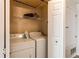 Bright laundry room featuring a washer, dryer, storage shelf, and hanging rack for convenience at 8500 E Jefferson Ave # 7B, Denver, CO 80237