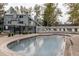 A sparkling community pool invites relaxation with lounge chairs and a lush setting surrounded by trees at 8500 E Jefferson Ave # 7B, Denver, CO 80237