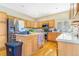 Efficient kitchen featuring wood cabinets, stainless appliances, an island and hardwood floors at 10301 E 112Th Way, Commerce City, CO 80640