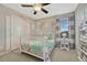 Cozy bedroom with a ceiling fan, a crib and decorated with flower-themed accents at 2896 Setting Sun Ave, Castle Rock, CO 80109