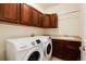 Well-lit laundry room with front load washer and dryer, cabinets, and sink at 10100 Bluffmont Ln, Lone Tree, CO 80124