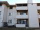 Exterior view showing stacked balconies and neutral siding with visible utility meters and ground-level patio at 2231 Sable Blvd # 909, Aurora, CO 80011
