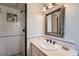 Clean and functional bathroom with a tiled shower stall, and a decorative mirror above the sink at 11754 W 28Th Ave, Lakewood, CO 80215