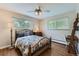 Comfortable bedroom featuring two windows, a patterned quilt, and a floor lamp at 11754 W 28Th Ave, Lakewood, CO 80215