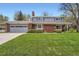 Traditional two-story home with a brick and siding exterior, a well-manicured lawn, and attached garage at 11754 W 28Th Ave, Lakewood, CO 80215