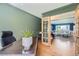Inviting home office with a spacious desk, green walls, hardwood floors, and an open doorway to the living room at 11754 W 28Th Ave, Lakewood, CO 80215
