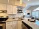 Modern kitchen with white cabinets, granite counters & breakfast bar at 4760 S Wadsworth Blvd # H207, Littleton, CO 80123