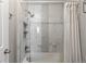 Shower in bathroom features marble-style tile with a decorative mosaic tile accent strip and built-in storage shelves at 9758 Laredo St # 18D, Commerce City, CO 80022