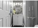 Cozy half bathroom featuring a modern vanity, stylish mirror, and attractive stone accent wall at 9758 Laredo St # 18D, Commerce City, CO 80022