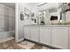 Bright bathroom vanity with double sinks, large mirror, and decorative backsplash at 9758 Laredo St # 18D, Commerce City, CO 80022