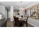 Dining room showcases a modern chandelier, hardwood floors, large mirror, and view into the kitchen at 9758 Laredo St # 18D, Commerce City, CO 80022