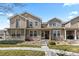 Exterior of home with stone accents, beige siding, small porch, and landscaped front yard at 9758 Laredo St # 18D, Commerce City, CO 80022