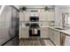 Updated kitchen with stainless steel appliances, light colored cabinets, marble countertops, and modern backsplash at 9758 Laredo St # 18D, Commerce City, CO 80022