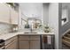 Kitchenette area showcasing light-colored cabinetry, stainless steel appliances, and views into the living room at 9758 Laredo St # 18D, Commerce City, CO 80022