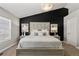 This bright main bedroom has an upholstered headboard, a black accent wall, and bedside tables with lamps at 9758 Laredo St # 18D, Commerce City, CO 80022