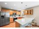 Bright kitchen boasts stainless steel appliances, wooden cabinets, hardwood floors and breakfast bar at 12552 Tammywood St, Broomfield, CO 80020