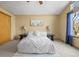 Main bedroom with ceiling fan, beige walls, carpeted floors, and view of backyard trees at 12552 Tammywood St, Broomfield, CO 80020
