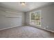 Bright bedroom with neutral walls, carpeting, and a large window offering natural light and shelving at 1043 Lilac Ct, Broomfield, CO 80020