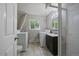 Laundry room with washer, dryer, window, sink with vanity, and a standing shower with glass doors at 1043 Lilac Ct, Broomfield, CO 80020