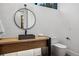 Modern half-bath with vessel sink, round mirror, and neutral tones at 2475 S Saint Paul St, Denver, CO 80210