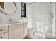 Bright bathroom featuring white marble in shower, round mirror, and sink vanity at 2475 S Saint Paul St, Denver, CO 80210