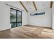 Bright bedroom with a large window and hardwood floors complemented by wooden ceiling beams at 2475 S Saint Paul St, Denver, CO 80210