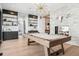 Bright game room with exposed beam pool table, modern fireplace, and built-in shelving at 2475 S Saint Paul St, Denver, CO 80210