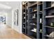 Bright hallway featuring dark shelving and art accents on white walls and hardwood floors at 2475 S Saint Paul St, Denver, CO 80210