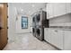 Clean laundry room featuring stacked washer and dryer with white custom cabinets at 2475 S Saint Paul St, Denver, CO 80210