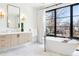 Bright bathroom featuring a modern soaking tub, large window and dual sink vanities at 2475 S Saint Paul St, Denver, CO 80210