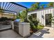 Outdoor kitchen area with stainless steel grill, countertop space, and lush landscaping at 2475 S Saint Paul St, Denver, CO 80210